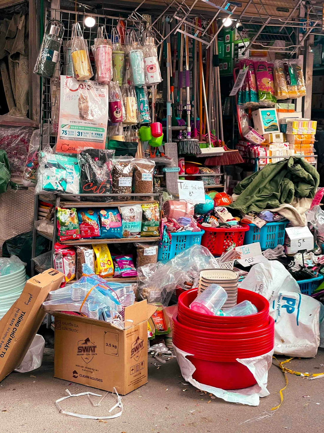 A cluttered stall selling various household goods and supplies.